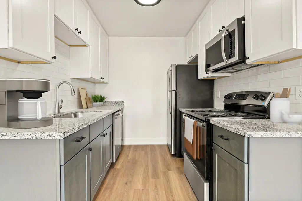 One Bedroom Apartments In El Cajon, CA - Terraza Hills - Kitchen Featuring Stainless-Steel Appliances, Wood-Style Flooring, And Tile Backsplash