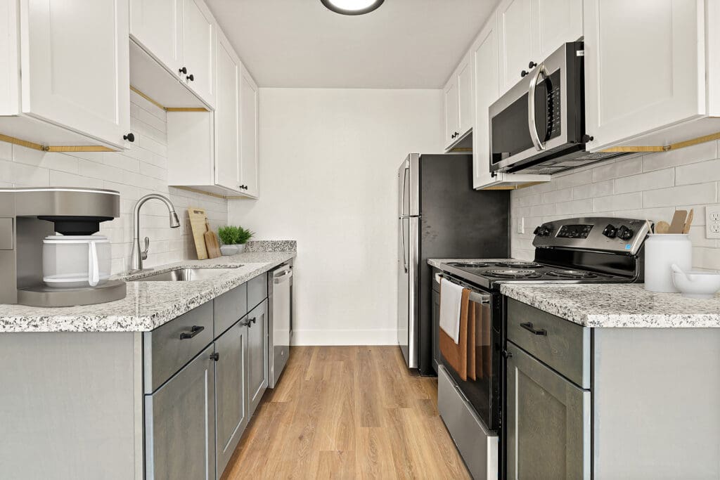 One Bedroom Apartments In El Cajon, CA - Terraza Hills - Kitchen Featuring Stainless-Steel Appliances, Wood-Style Flooring, And Tile Backsplash